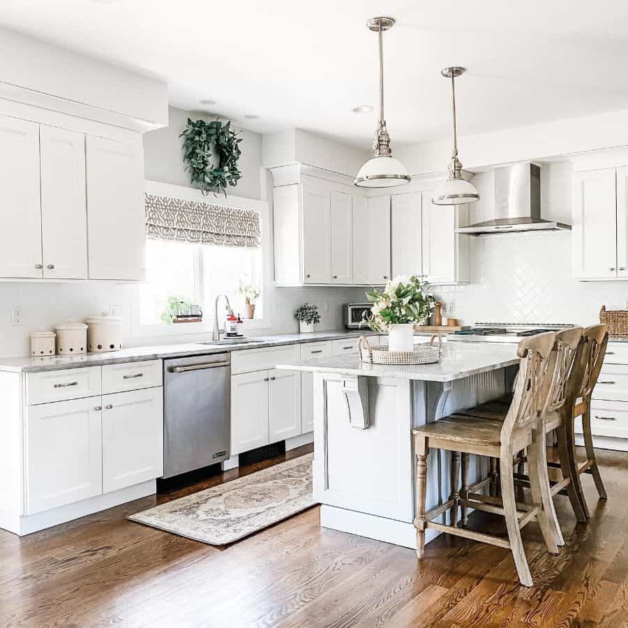 elegant farmhouse kitchen with white cabinets and vintage chairs 