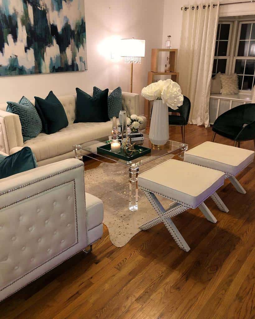 white living room glass table white footrests two black chairs blue cushions 