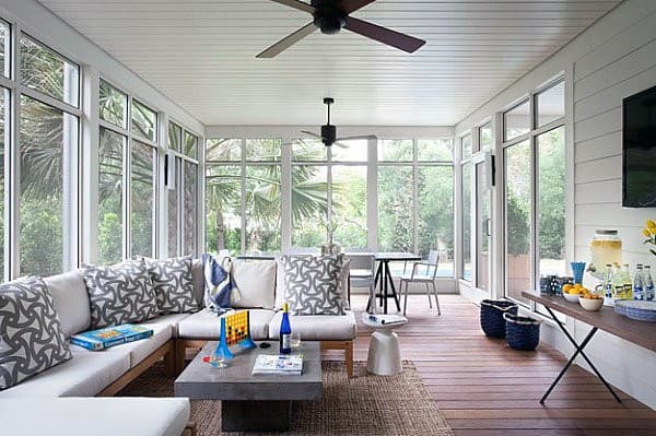 Bright sunroom with a white shiplap ceiling, L-shaped sofa, and modern coffee table.