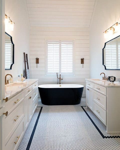 Elegant bathroom with a black freestanding tub, white shiplap walls, and hexagonal tile flooring.