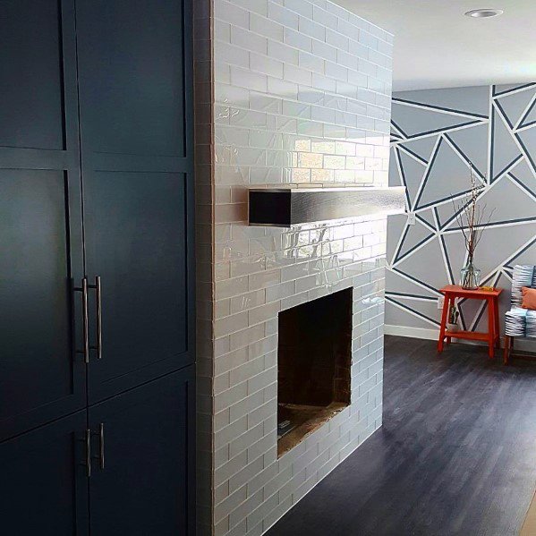 White subway-tiled fireplace with a dark wooden mantel in a modern living room.