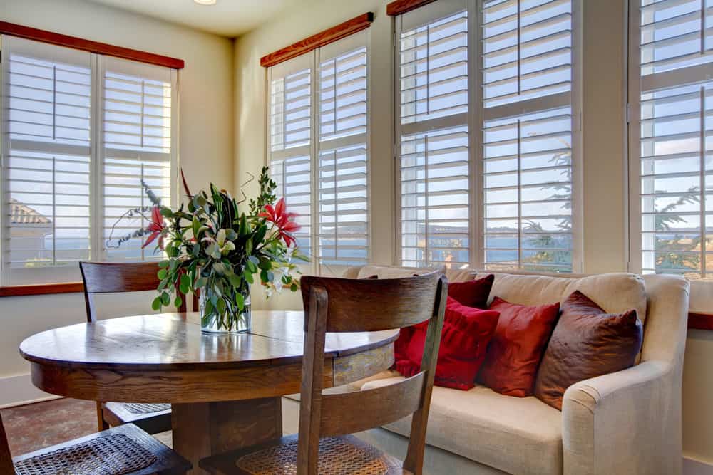 window shutters living room white sofa wood table and chairs 