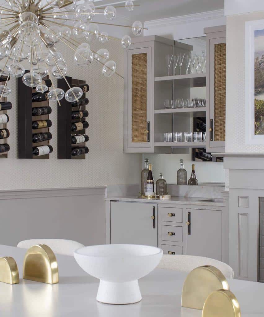 Elegant wet bar with gold accents, modern wine racks, and mirrored backsplash for a sophisticated touch.