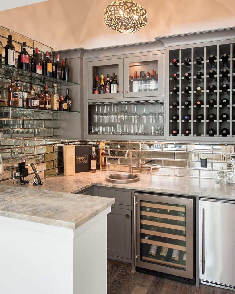 Elegant wet bar with mirrored backsplash, integrated wine storage, and sleek glass shelving for a modern touch.