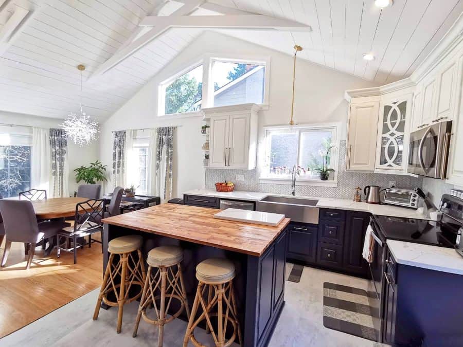 blue cabinet kitchen with large island and vaulted ceiling 