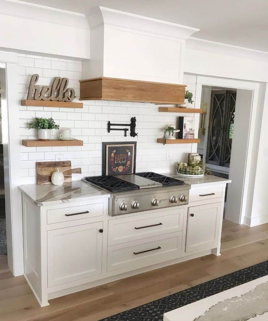 white cabinet kitchen with tile backsplash and wood wall shelves