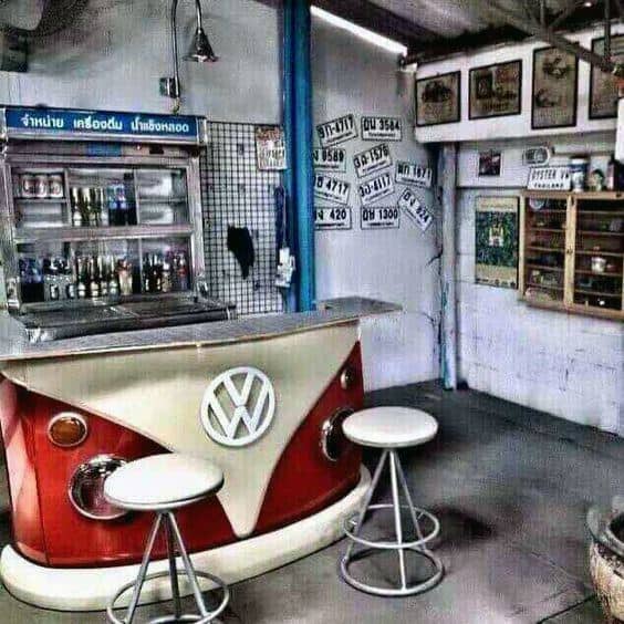 Retro garage bar with a VW van counter, metal stools, and vintage wall decor.