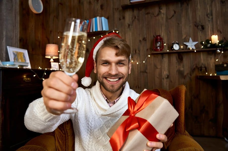 young man wearing santa hat holding Christmas gift