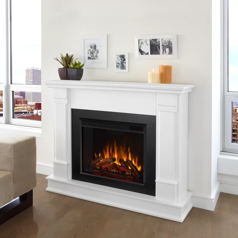 White mantel electric fireplace with glowing logs and modern living room decor.